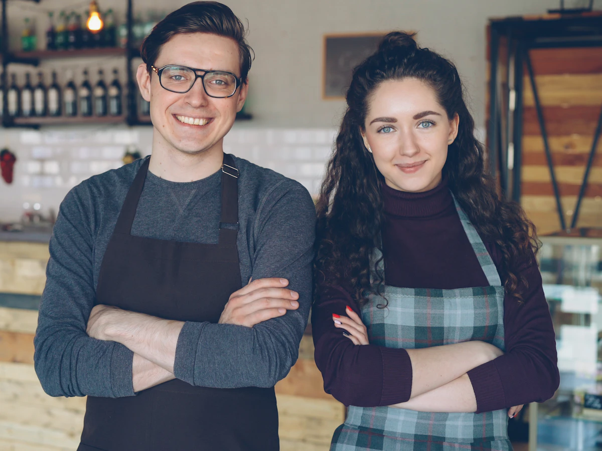Two local café owners standing proudly together in their shop