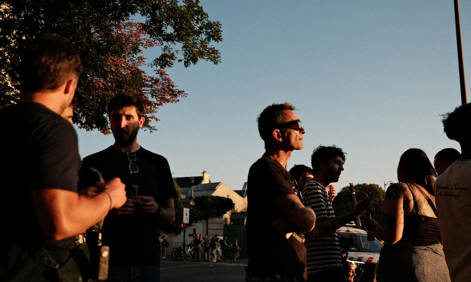 A group of friends socialising outdoors in warm late-afternoon light